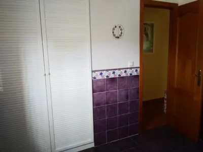 a bathroom with purple tiles and a clock on the wall at Casa SUROESTE - Zona El Colorado, Conil de la Frontera in Roche