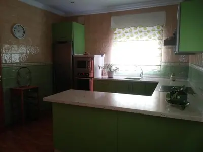 a kitchen with green cabinets and a sink and a window at Casa SUROESTE - Zona El Colorado, Conil de la Frontera in Roche
