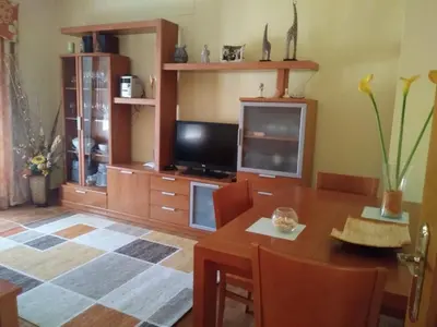 a living room with a wooden table and a television at Casa SUROESTE - Zona El Colorado, Conil de la Frontera in Roche
