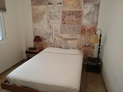 a bedroom with a bed and a wall with maps at Cádiz Un respiro en Cádiz in Cádiz