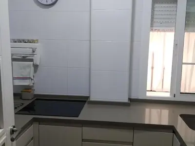 a kitchen with white walls and a clock on the wall at Cádiz Un respiro en Cádiz in Cádiz