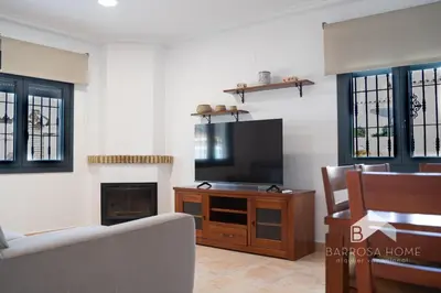 a living room with a television and a fireplace at Villa Cañuela in Chiclana de la Frontera
