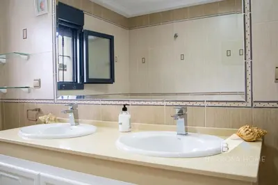 a bathroom with two sinks and a large mirror at Villa Cañuela in Chiclana de la Frontera