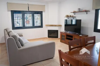 a living room with a couch and a tv at Villa Cañuela in Chiclana de la Frontera