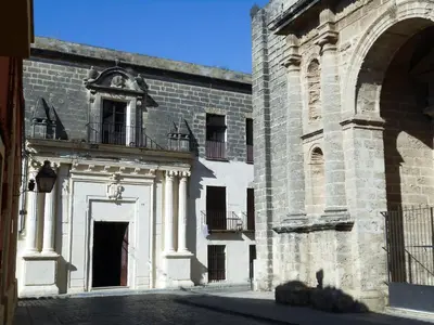 a large brick building with a door and a balcony at Casa Palacio Morla y Melgarejo in Jerez de la Frontera