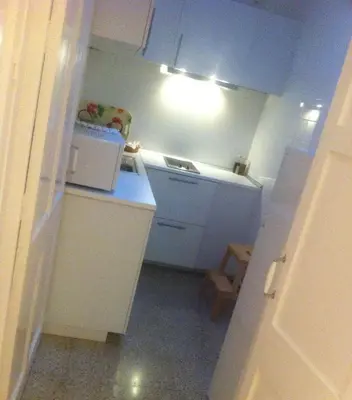 a small kitchen with white cabinets and a microwave at Casa Palacio Morla y Melgarejo in Jerez de la Frontera