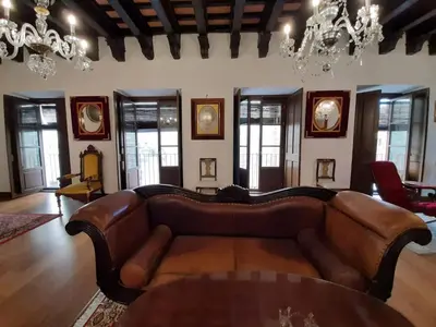 a living room with a leather couch and a table at Casa Palacio Morla y Melgarejo in Jerez de la Frontera