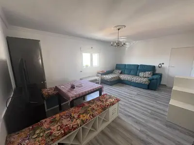 a living room with a blue couch and a table at Churruca 3 Preferentemente para familias y mayores de 25 años in El Puerto de Santa María
