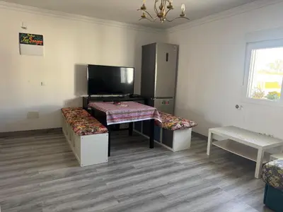 a room with a table and bench and a tv at Churruca 3 Preferentemente para familias y mayores de 25 años in El Puerto de Santa María