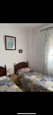 a bedroom with two beds and a window at villa los gallos 10 in Chiclana de la Frontera