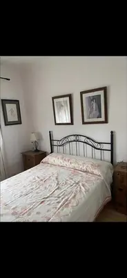 a bedroom with a bed and three pictures on the wall at villa los gallos 10 in Chiclana de la Frontera