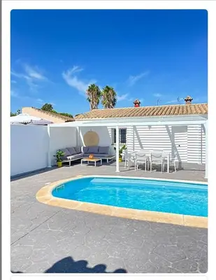 a swimming pool in front of a house at Villa ELY in Chiclana de la Frontera