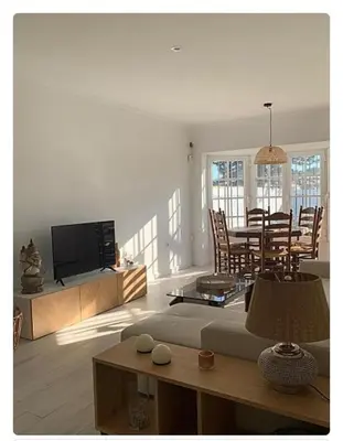 a living room with a television and a dining room at Villa ELY in Chiclana de la Frontera
