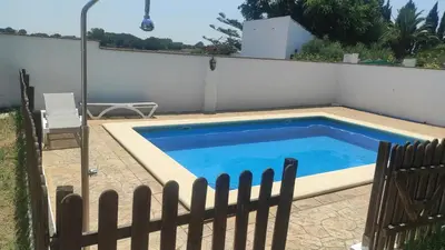 a swimming pool next to a white fence at CASA ALBA in Conil de la Frontera