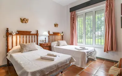 a bedroom with two beds and a window at Family country house with pool in Conil in Cádiz