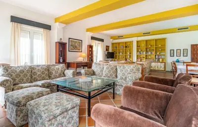 a living room with couches and a glass table at Family country house with pool in Conil in Cádiz