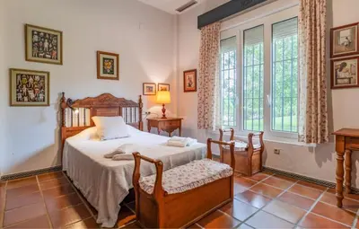 a bedroom with a bed and a large window at Family country house with pool in Conil in Cádiz