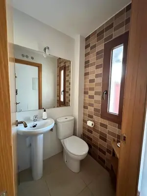 a bathroom with a white toilet and a sink at Casa de playa nueva y luminosa in Chiclana de la Frontera