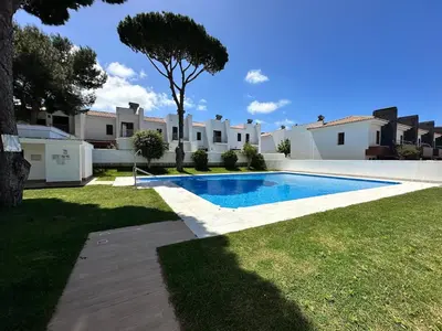 a swimming pool in the yard of a house at Casa de playa nueva y luminosa in Chiclana de la Frontera