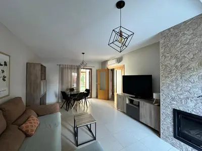 a living room with a couch and a tv at Casa de playa nueva y luminosa in Chiclana de la Frontera