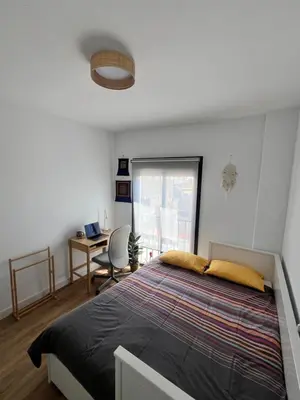 a bedroom with a bed and a desk and a window at GATU Rubí in El Puerto de Santa María