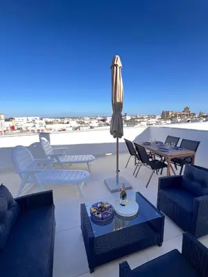 a patio with chairs and tables and an umbrella at GATU Rubí in El Puerto de Santa María