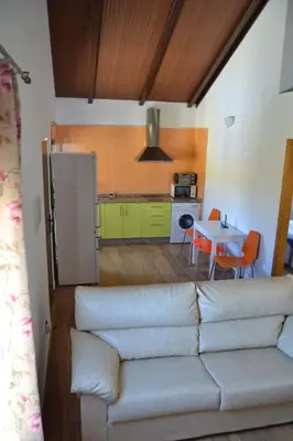 a living room with a couch and a kitchen at CASA Marimonte in Conil de la Frontera