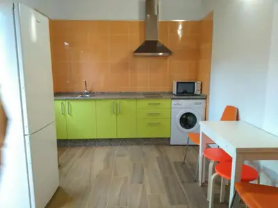 a kitchen with green cabinets and a table with chairs at CASA Marimonte in Conil de la Frontera
