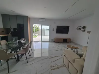 a living room with a couch and a dining room at Casitalola in Conil de la Frontera