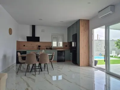 a kitchen and dining room with a table and chairs at Casitalola in Conil de la Frontera