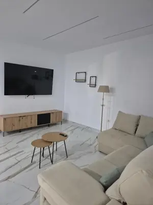 a white living room with a couch and a tv at Casitalola in Conil de la Frontera