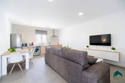 a living room with a couch and a table and a kitchen at Sauz A in Novo Sancti Petri