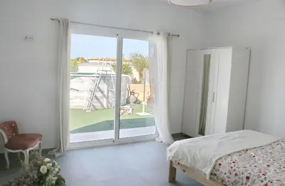 a bedroom with a bed and a large sliding glass door at Villa Buganvilla in Conil de la Frontera