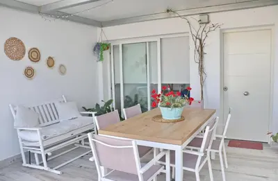 a dining room with a wooden table and chairs at Villa Buganvilla in Conil de la Frontera
