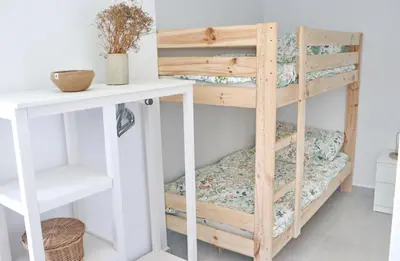 a wooden bunk bed in a room with a table at Villa Buganvilla in Conil de la Frontera
