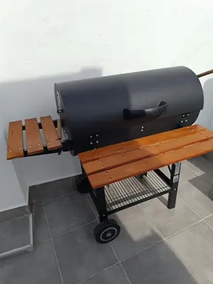 a grill and a bench next to a wall at Apartamentos Bajo Guía in Sanlúcar de Barrameda