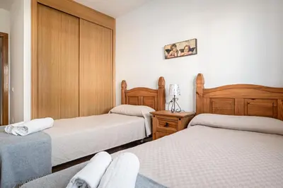 a bedroom with two beds and wooden cabinets at coto 7 8 in Chiclana de la Frontera