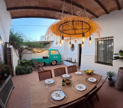 a wooden table in a patio with a table and chairs at Dolce Vita Chiclana in Chiclana de la Frontera