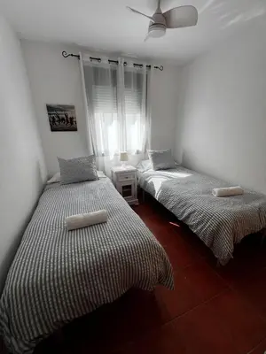 two twin beds in a room with a window at Apartamento Riviera in Novo Sancti Petri