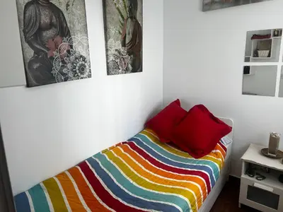 a bedroom with a bed with three pictures on the wall at El rincón de Malandar in Sanlúcar de Barrameda