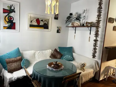 a living room with a table and a dog on a couch at El rincón de Malandar in Sanlúcar de Barrameda