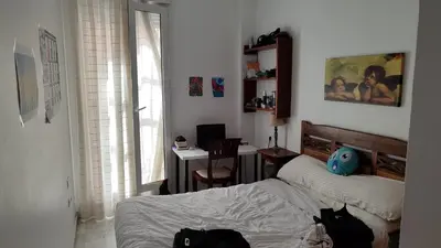 a bedroom with a bed and a desk with a computer at El Falla in Cádiz