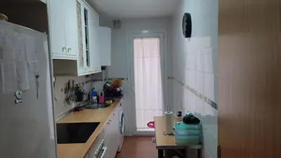 a kitchen with white cabinets and a sink and a window at El Falla in Cádiz