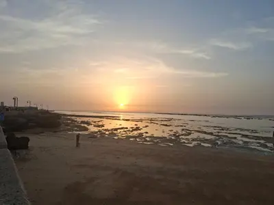 a sunset on the beach with the sun setting at El Falla in Cádiz