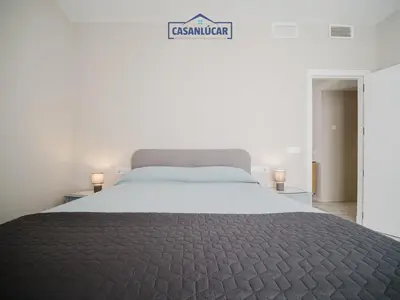 a bedroom with a large bed and a sign that readscussion at Piso Atlantis in Sanlúcar de Barrameda