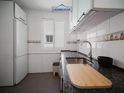 a kitchen with a sink and a wooden counter top at Piso Atlantis in Sanlúcar de Barrameda