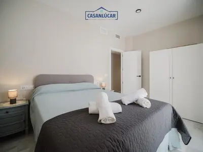 a bedroom with a bed with towels on it at Piso Atlantis in Sanlúcar de Barrameda
