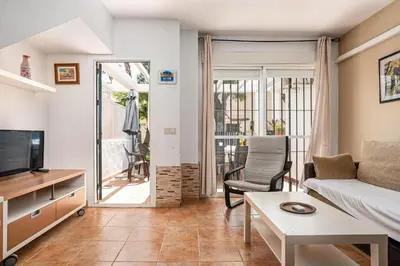 a living room with a couch and a tv at Balconera 79 in Chiclana de la Frontera