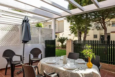a patio with a table and chairs and an umbrella at Balconera 79 in Chiclana de la Frontera