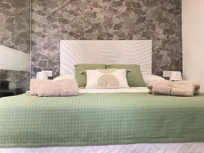 a bedroom with a green bed with two pillows at Apartamento La Guitarra in Jerez de la Frontera